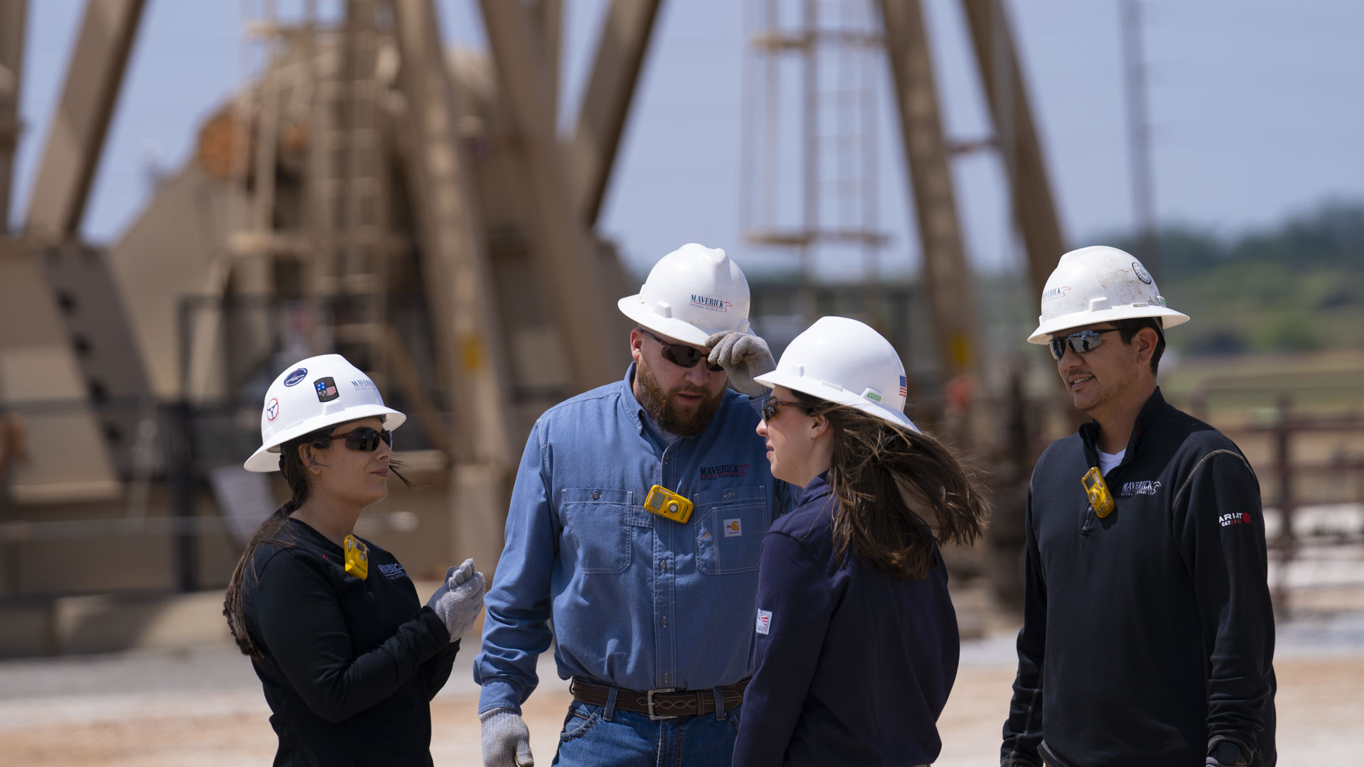 Maverick personnel in hard hats and safety gear at field operations site