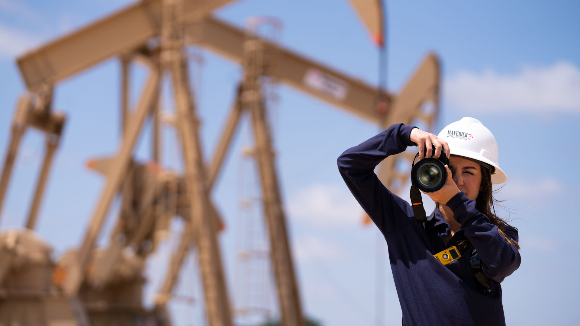 Maverick employee taking a photo pumpjacks at the company site